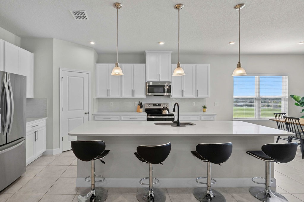 Gourmet kitchen with quartz counters and breakfast-bar island