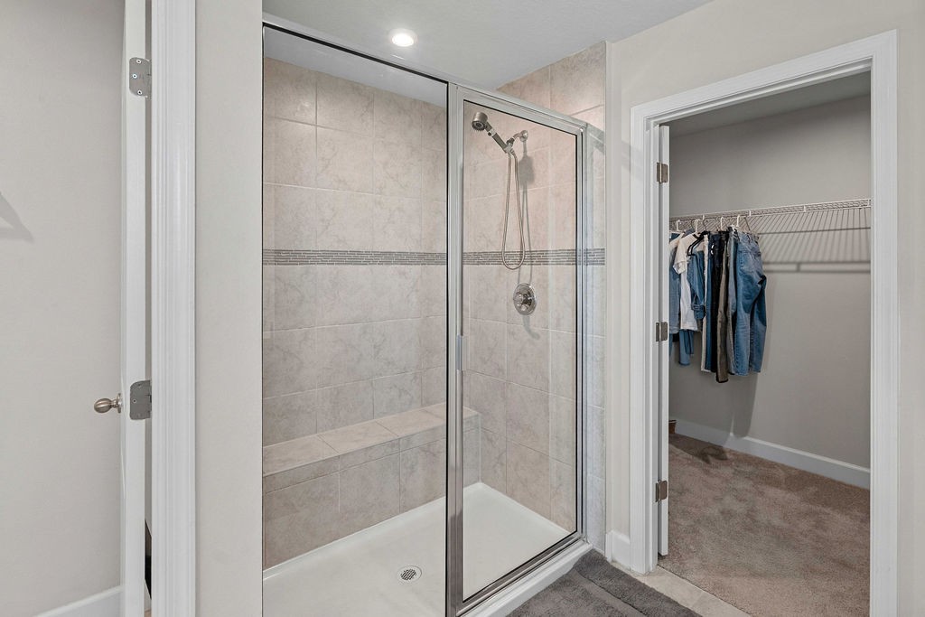 Primary bath with dual quartz vanity and bench-seat walk-in shower